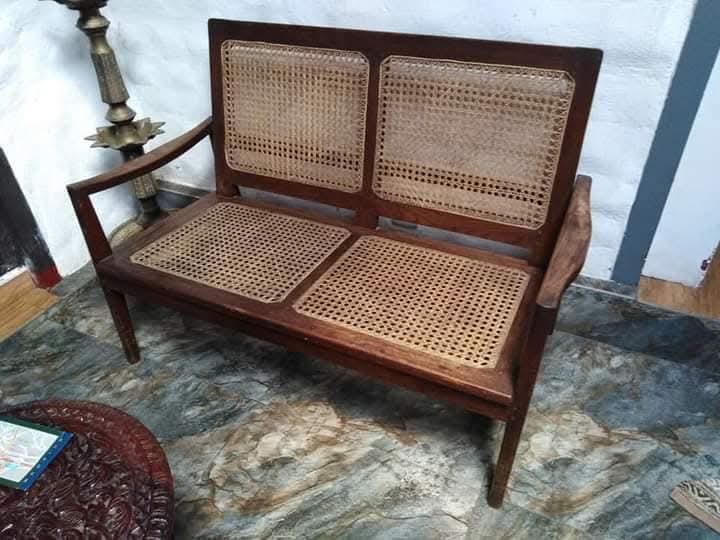 Two-seater cane sofa after with striped cushion
